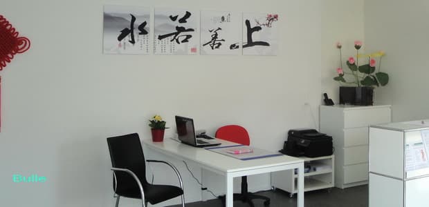 Cabinet RuiHua SwisSinoMed à Bulle : bureau de consultation, calligraphies et fleurs de lotus